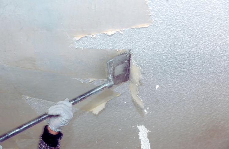 Scraping texture from a popcorn ceiling during removal